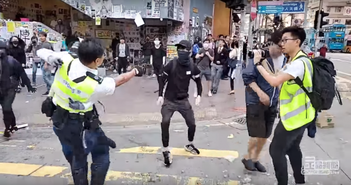 Deux manifestants à terre après qu'un policier hongkongais a ouvert le feu sur eux (capture live cupid producer)